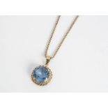 A yellow metal and blue topaz pendant on a 9ct gold box linked chain, the circular cut pendant in