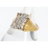 A continental yellow metal diamond cross over ring, set with fifteen brilliant cuts in claw