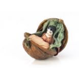 A 19th century walnut case, in two halves and opening to reveal a miniature porcelain doll
