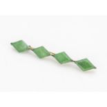 A Chinese jadeite jade four panel brooch, the lozenge shaped panels in a yellow metal mount, 5.5