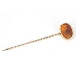 An antique paste intaglio oval stick pin, the yellow metal pin, with oval mount, centred with