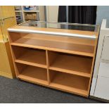 A contemporary counter top display, having open back section with two banks of two deep shelves