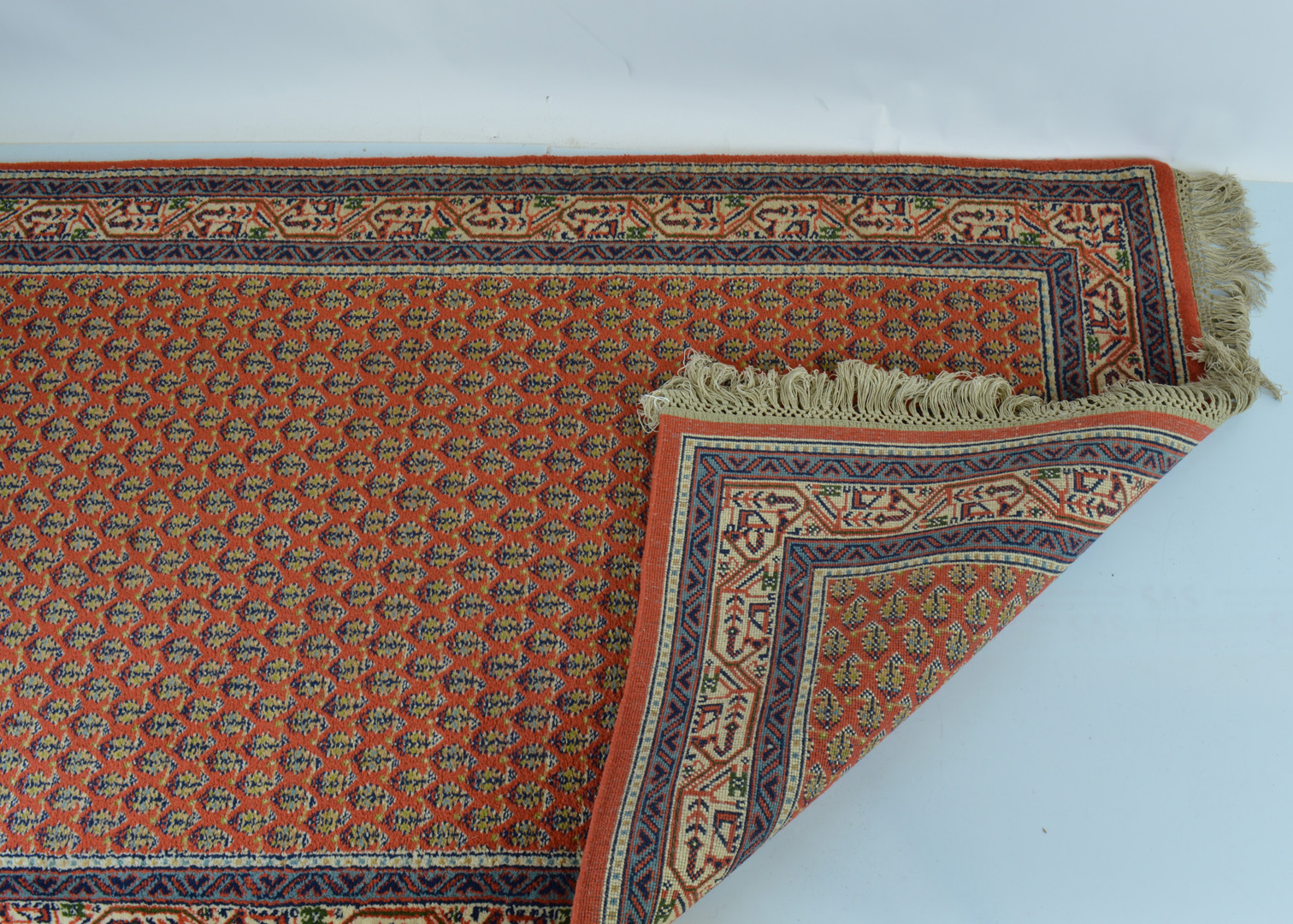 A late 20th century woollen signed carpet, central all over 'mother and child' motif pattern