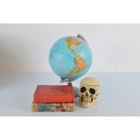 A students globe, 39 cm high, together with a skull tobacco pot and cover, two 1930s travel books