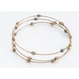 A contemporary 9ct gold expanding wire and bead bangle, closed 5.5cm, 4.6g