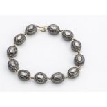 A continental double sided diamond line bracelet, the oval links set with flattened ct rough