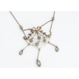 An Edwardian 15ct gold and seed pearl pendant and chain, open design with bow and swags supporting