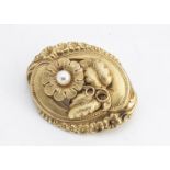 A continental yellow metal and cultured pearl oval brooch, of floral design with a leaf and flower