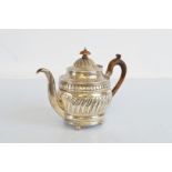 A George III silver and later decorated tea pot, circular shape with later embossed decoration,