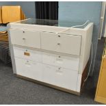 A counter top display cabinet, having two banks of three drawers to rear, plinth base, 120cm x