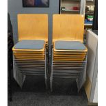 Twenty four bent plywood retro style stacking chairs, with metal frames and upholstered seats,