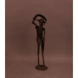 A 20th century contemporary African cast metal sculpture of a man, in Benin style, 47cm high, with