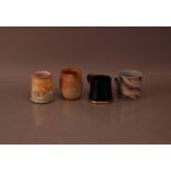 Three contemporary studio pottery mugs, comprising a black and gilt mug with ribbon design by