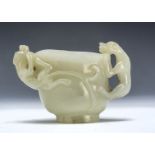 A 19th century Chinese Jadeite Jade libation cup, the sides with two climbing dogs, 7.5cm high
