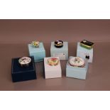 A collection of Halcyon Days enamel boxes, all floral themed, one egg shape example, all with