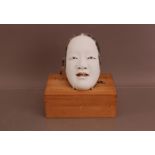 An early 20th century Japanese wooden mask, 20cm x 13cm, with a character mark to the reverse, in