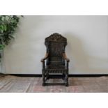 A restored 17th century and later oak hall chair, the back panel with the face of the green man