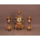A 20th century metal and enamel clock garniture, in Rococo style, the clock 42cm high, with an acorn