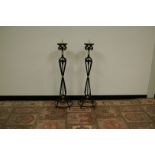 A pair of wrought iron prickett candlesticks, painted black with gilt embellishment, 112cm (2)