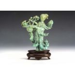 A early 20th century Chinese turquoise stone carved figure, the figure holding a large basket of