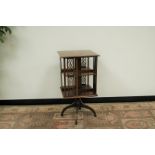 A Edwardian mahogany and boxwood inlaid revolving library bookcase, the square top with central