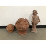 A modern terracotta garden ornament and two others, including a large basket of fruit, another small