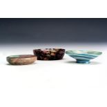 Three small carved far eastern vessels, comprising a Rhodonite example 6.5cm wide, together with a