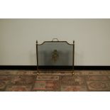 A Edwardian brass fire screen, with wreath and armorial to centre