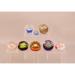 A collection of glass paperweights, some with millefiori design others with flowers, by various