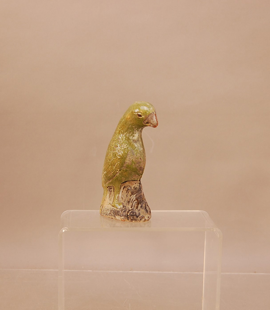 An early 19th century 'Diana Cargo' glazed ceramic Parrot, 15.5cm high green glaze (worn),