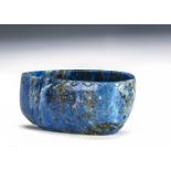 A far eastern Lapis hardstone carved vessel, with a crudely carved rim, 4.25cm H x 8.5cm W