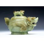 An early 20th century hardstone carved vessel and cover, the lid mounted with a mythical creature,
