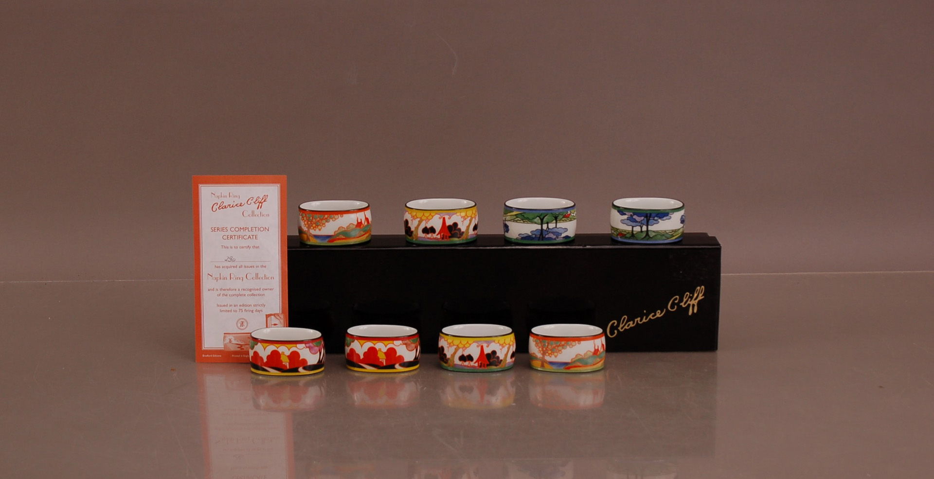 A set of eight Clarice Cliff napkin rings, in a Clarice Cliff retail box with certificate