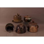 A group of studio ceramics, comprising two plates and covers, two lidded urns, on with a cover