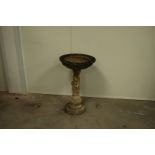 A cast concrete garden bird bath, circular top on a foliate design column, 68cm high, the top 41cm