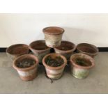 A group of eight terracotta garden pots, a larger pair 35cm diameter and 27cm high, a set of four