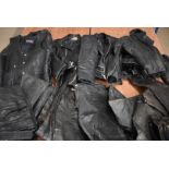 A collection of all black Motorcycle leather clothing, comprising four jackets, a waistcoat, and six