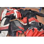 An assortment of Motorcycle leather, including one full leather, two jacket and trouser sets, and