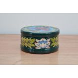 A Moorcroft pottery lidded cicular box, Saadian' pattern, 2001, 8.5cm high and 16cm diameter, in a