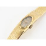 An continental yellow metal ladies watch, textured bracelet, and oval dial with Arabic and baton