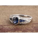 A continental white metal sapphire and diamond Art Deco style dress ring, oval mixed cut sapphire in