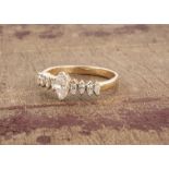 A continental yellow metal diamond set dress ring, the central marquise cut diamond flanked by