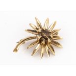 A 9ct gold and citrine flower brooch, the round mixed cut citrine in closed claw setting, marked