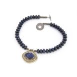 A lapis lazuli and white metal necklace pendant, the oval shaped pendant in a white metal mount,