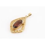 A 9ct gold and citrine open work pendant, of oval shape with a central mixed cut citrine, within a