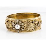 A French marked yellow metal enamel, diamond and seed pearl bangle, the thick bangle, centre set