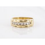 A continental yellow metal and cz set dress ring, channel set with shaped outline, marked 750 to