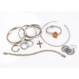 A collection of silver jewellery, comprising various white metal bangles, a torque, an amber bangle,