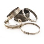 A collection of silver and white metal bangles, including a Victorian example, another marked