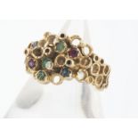 A 9ct gold vintage designer ring, of pierced circle design with multi gem set top set with ruby,